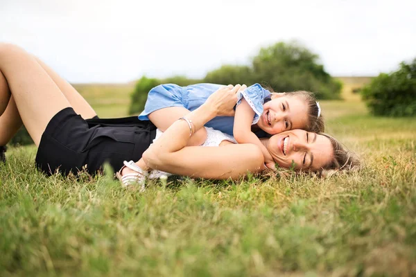 Lycklig mor med sin dotter låg på marken — Stockfoto