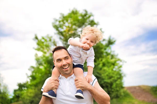 Father and his cute baby boy having fun outdoors on shoulder — Stock Photo, Image