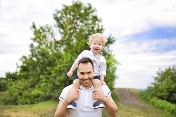 Батько і його милий хлопчик розважається на відкритому повітрі на плечі — стокове фото