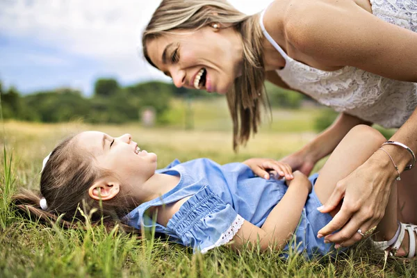 Happiness mother with her daughter lay on the ground — Stock Photo, Image