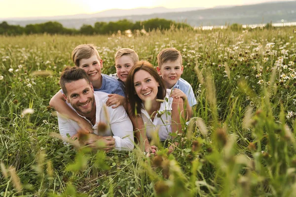 Happy family on daisy field at the sunset having great time together — Stock Photo, Image