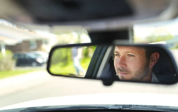 Un retrato del hombre en su coche se ven bonitas vistas desde el espejo —  Fotos de Stock