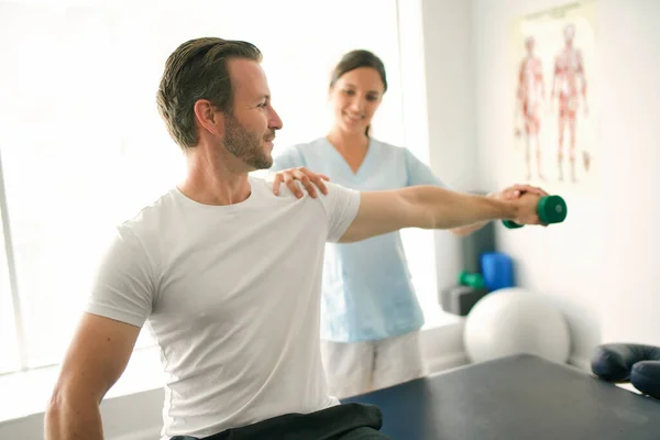 Physiothérapeute faisant un traitement avec le patient dans un bureau lumineux — Photo