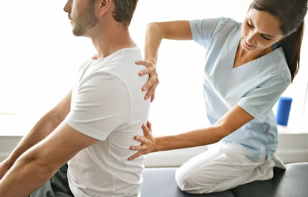 Physiothérapeute faisant un traitement avec le patient dans un bureau lumineux — Photo