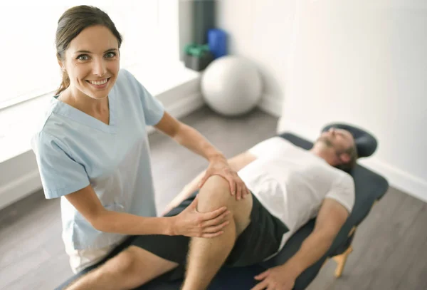 Fisioterapeuta haciendo tratamiento con paciente en consultorio luminoso — Foto de Stock