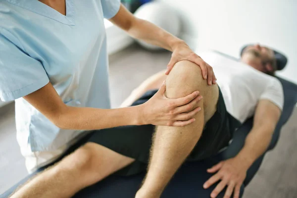 Physiotherapeut behandelt Patientin im hellen Büro — Stockfoto