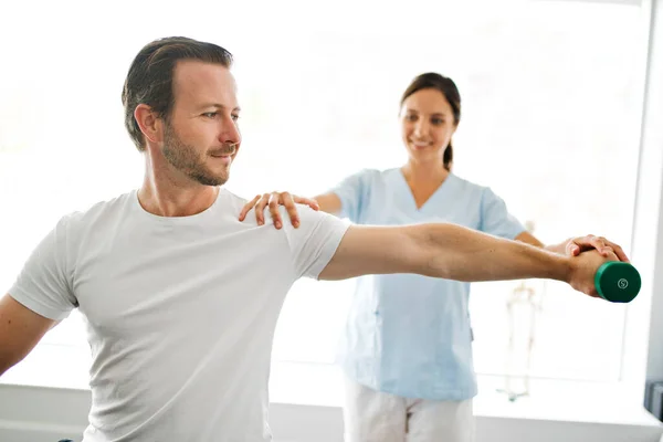 Physiothérapeute faisant un traitement avec le patient dans un bureau lumineux — Photo