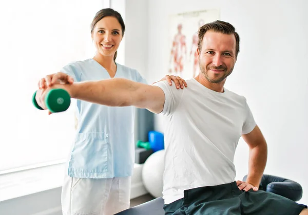 Fysiotherapeut doet behandeling met patiënt in helder kantoor — Stockfoto