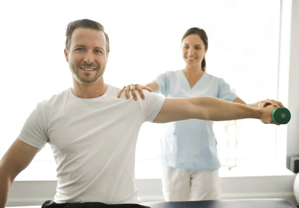 Physiothérapeute faisant un traitement avec le patient dans un bureau lumineux — Photo