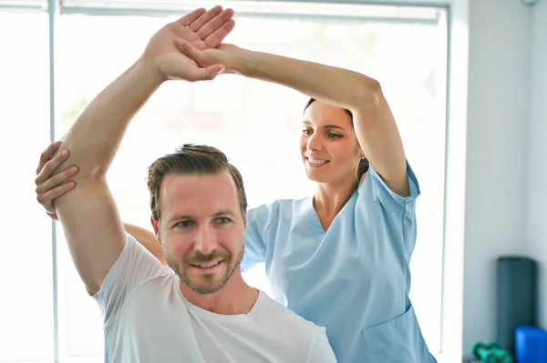 Physiotherapist doing treatment with patient in bright office — Stock Photo, Image