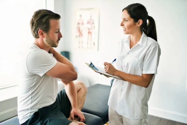 Physiothérapeute faisant un traitement avec le patient dans un bureau lumineux — Photo