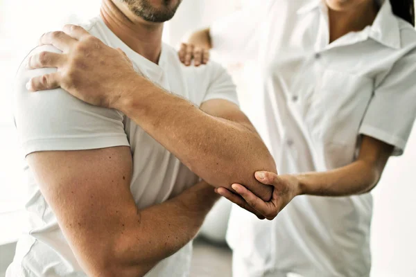 Physiothérapeute faisant un traitement avec le patient dans un bureau lumineux — Photo