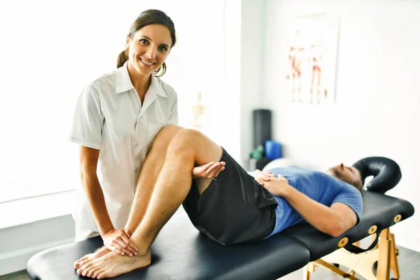 Fisioterapeuta haciendo tratamiento con paciente en consultorio luminoso — Foto de Stock