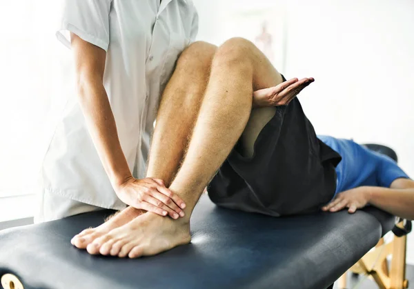 Physiotherapist doing treatment with patient in bright office — Stock Photo, Image