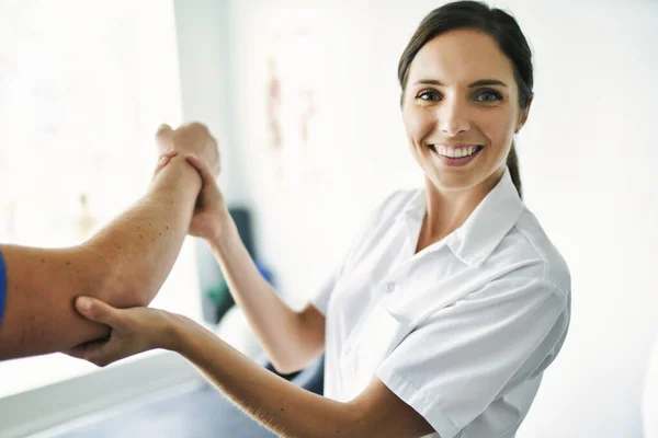 Physiotherapeut behandelt Patientin im hellen Büro — Stockfoto