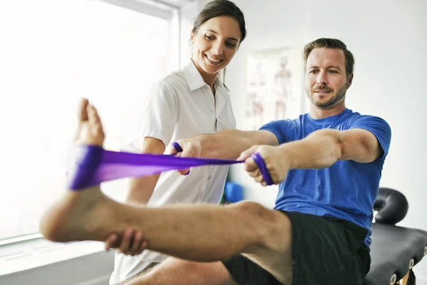 Fysiotherapeut doet behandeling met patiënt in helder kantoor — Stockfoto