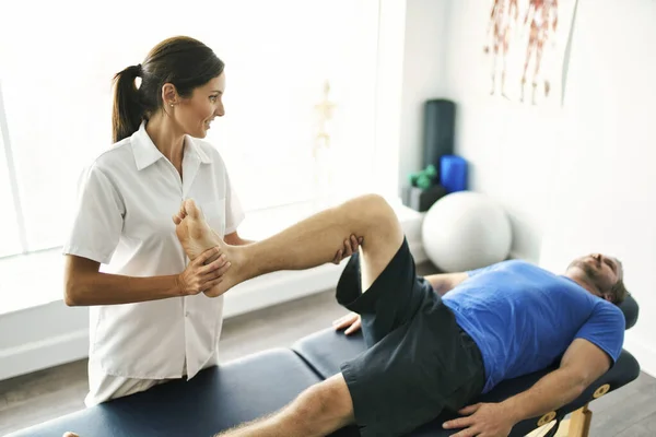 Fysiotherapeut doet behandeling met patiënt in helder kantoor — Stockfoto