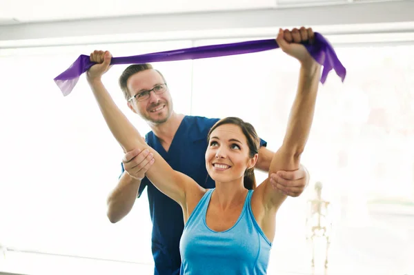 Man sjukgymnast Stretching en kvinnlig patient Långsamt. — Stockfoto