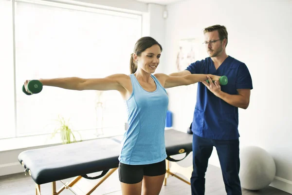 Man sjukgymnast Stretching en kvinnlig patient Långsamt. — Stockfoto