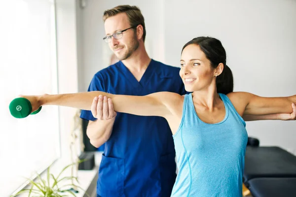 Fisioterapeuta masculino Estirando a una paciente femenina — Foto de Stock