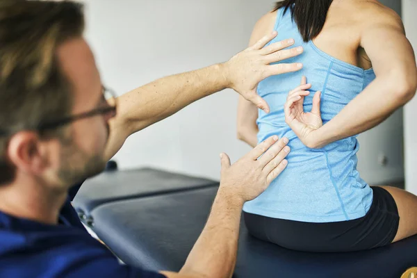 Fisioterapeuta Masculino Esticando uma Paciente Feminina Lentamente. — Fotografia de Stock