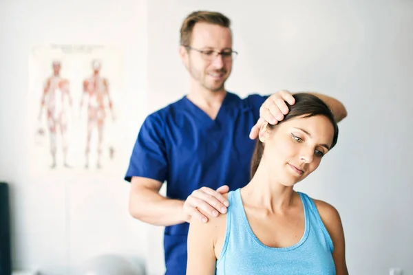 Maschio fisioterapista stretching un femmina paziente nack — Foto Stock