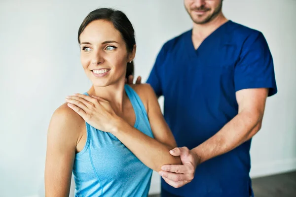 Fisioterapeuta Masculino Esticando uma Paciente Feminina Lentamente. — Fotografia de Stock