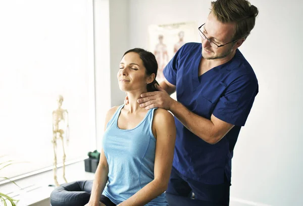 Maschio fisioterapista stretching un femmina paziente nack — Foto Stock