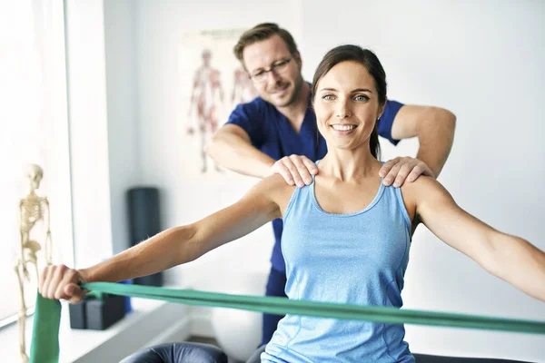 Man sjukgymnast Stretching en kvinnlig patient Långsamt. — Stockfoto