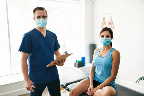 Fisioterapeuta Masculino Esticando uma Paciente Feminina Lentamente. — Fotografia de Stock