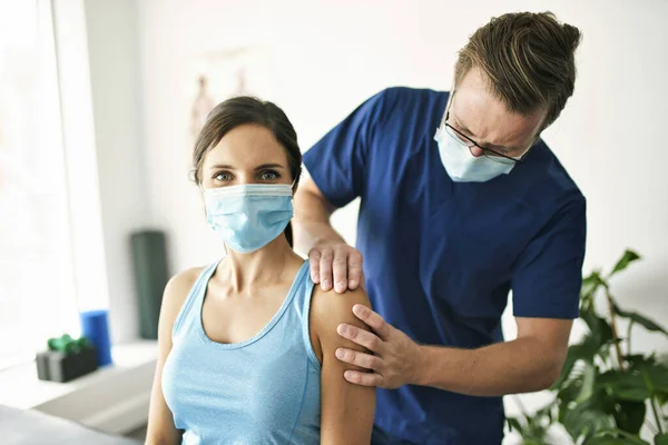 Fisioterapeuta Masculino Esticando uma Paciente Feminina Lentamente. — Fotografia de Stock