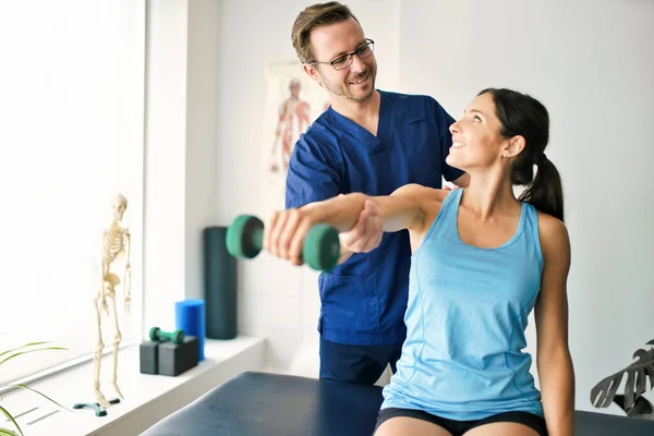 Männlicher Physiotherapeut streckt Patientin langsam. — Stockfoto