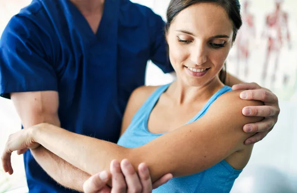 Male Physical Therapist Stretching a Female Patient Slowly. — Stock Photo, Image