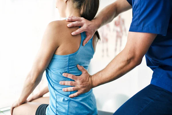 Fisioterapeuta masculino Estirando a una paciente femenina lentamente. — Foto de Stock