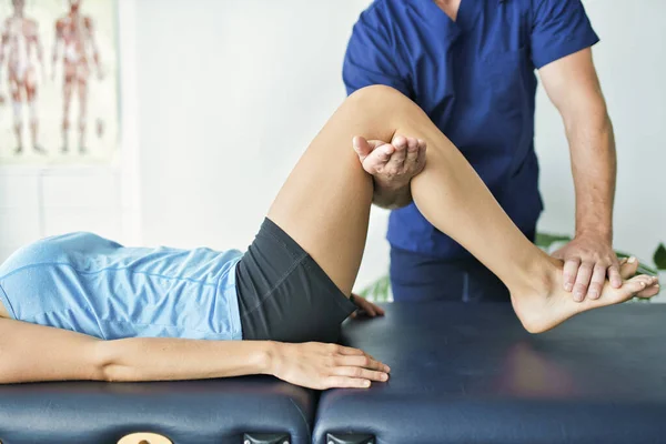 Fisioterapeuta masculino Estirando a una paciente femenina — Foto de Stock
