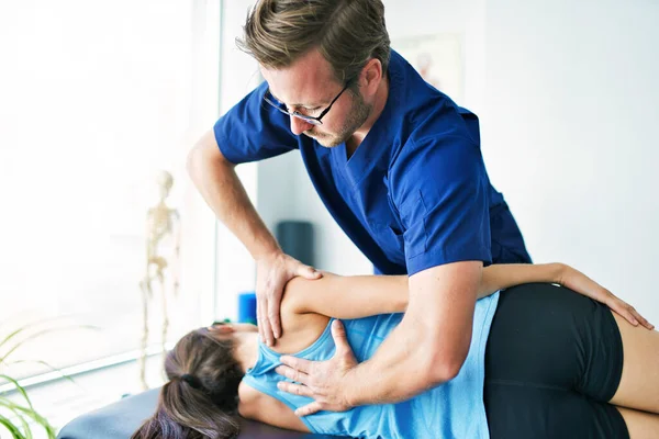 Mannelijke fysiotherapeut rekken van een vrouwelijke patiënt — Stockfoto