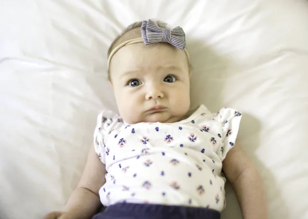 Happy newborn baby on the bed wearing cute clothes — Stock Photo, Image