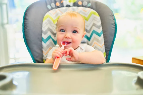 Bebé listo para la cena en la cocina con cuchara en la mano — Foto de Stock