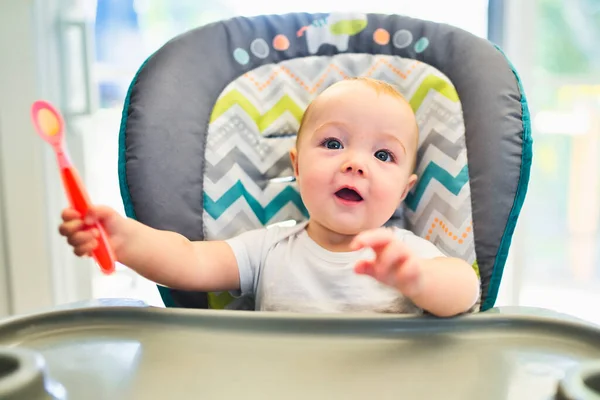 Bebé listo para la cena en la cocina con cuchara en la mano — Foto de Stock