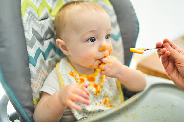 Gelukkig klein schattig baby meisje met puree voedsel overal — Stockfoto