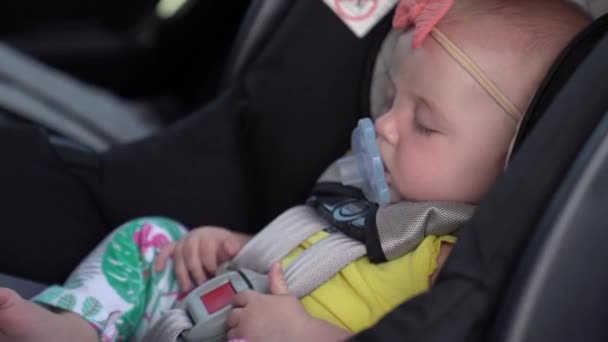 Dítě dívka spí v dětské bezpečnostní sedačce — Stock video