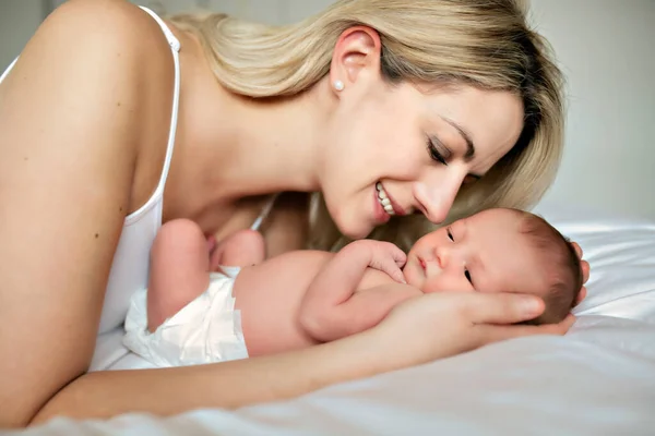 A woman with a newborn baby in bed — Stock Photo, Image