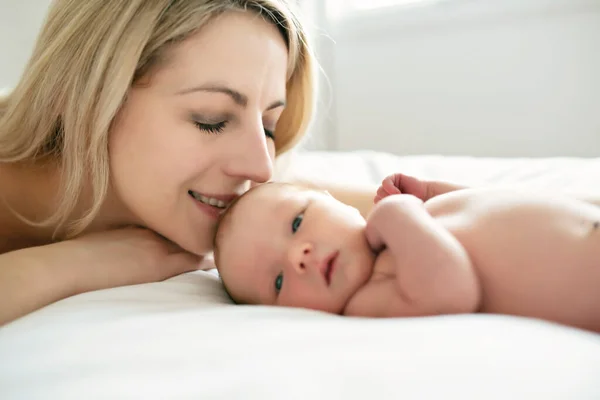 A woman with a newborn baby in bed — Stock Photo, Image