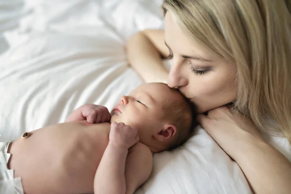 A woman with a newborn baby in bed — Stock Photo, Image