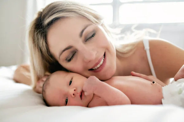 A woman with a newborn baby in bed — Stock Photo, Image