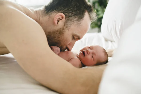 Um pai com um bebê recém-nascido na cama — Fotografia de Stock