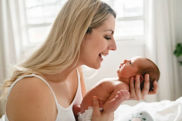 A woman with a newborn baby in bed — Stock Photo, Image