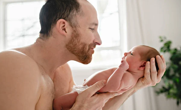 Um pai com um bebê recém-nascido na cama — Fotografia de Stock