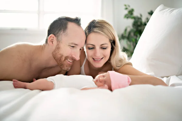 Un padre de familia con un bebé recién nacido en la cama — Foto de Stock