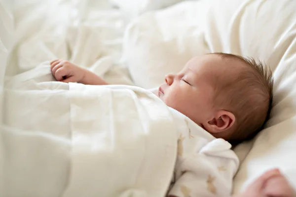 Uma doce menina recém-nascida dormindo na cama branca — Fotografia de Stock